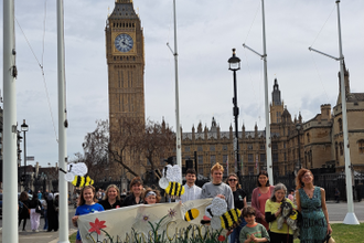 Campaigners with their beautiful handmade banner and giant bees outside Parliament