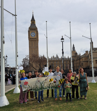 Campaigners with their beautiful handmade banner and giant bees outside Parliament