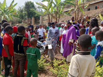 Parishioners and priest gather round new motorbike in Bamenda (© ACN)