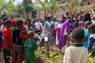 Parishioners and priest gather round new motorbike in Bamenda (© ACN)