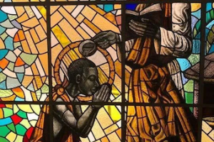 St Kizito being baptised by St Charles Lwanga. Stained glass at Munyonyo Martyrs Shrine, © Wikimedia