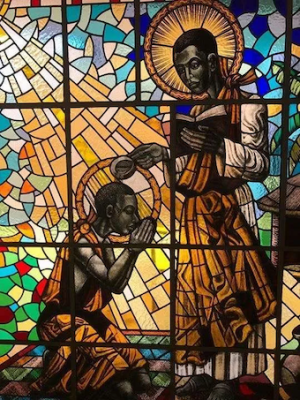 St Kizito being baptised by St Charles Lwanga. Stained glass at Munyonyo Martyrs Shrine, © Wikimedia