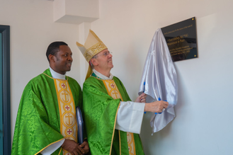 Fr Mejuru with Bishop Hudson unveiling the plaque at Holy Family Hall. Image: etinosa_osagie_films