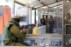 Israeli soldier faces Palestinians waiting at Huwara checkpoint, Nablus, Wiki Image: 12.06.06