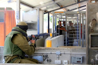 Israeli soldier faces Palestinians waiting at Huwara checkpoint, Nablus, Wiki Image: 12.06.06