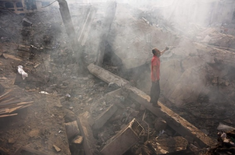 Palestinian man searches through wreckage of his home after an Israeli strike in Gaza. 24 July.