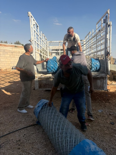 Adam Rabia, head of field operations, delivering fencing and flashlights to Abu Hamdan in Burqa.