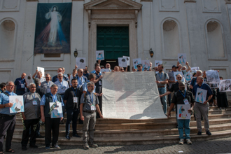 Priests with shroud bearing names of hundreds of children killed by Israel since the 'ceasefire'.