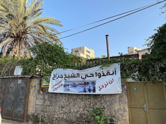 The Arabic sign reads: Save Shaykh Jarrah neighbourhood: We will not leave, we will remain steadfast