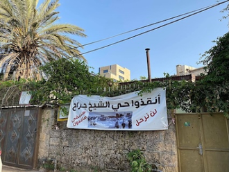 The Arabic sign reads: Save Shaykh Jarrah neighbourhood: We will not leave, we will remain steadfast