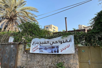 The Arabic sign reads: Save Shaykh Jarrah neighbourhood: We will not leave, we will remain steadfast